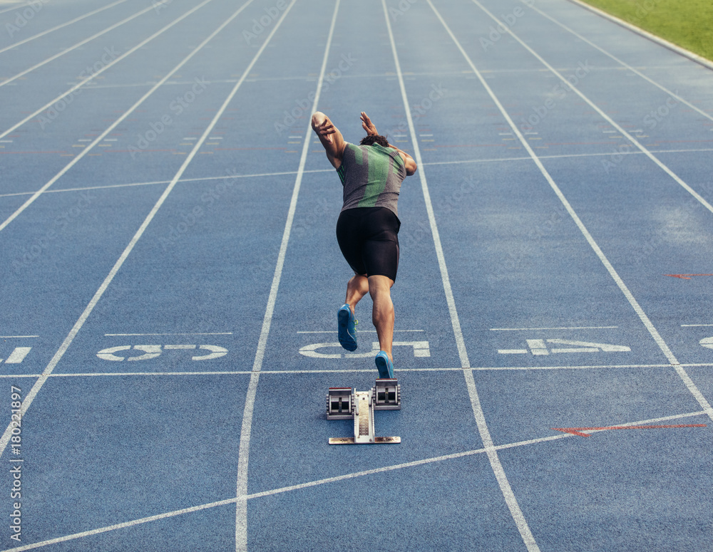 Wall mural sprinter taking off from starting block on track