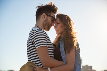Obraz premium Young happy man embracing his girlfriend outside
