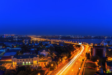 Fototapeta na wymiar Aerial panoramic view to the center or downtown of night Voronezh city, Russia, st. Stepan Razin, Chernavsky Bridge. Dramatic night cityscape, blurred car lights