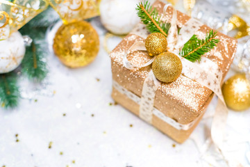 New Year's gift in a golden box, decorated with bart, Christmas tree branches and Christmas toys