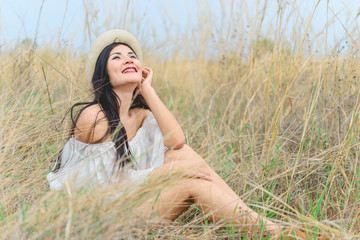 Portrait of asian beautiful woman feeling fresh hat in her hand at the field,wear denim with brown boot