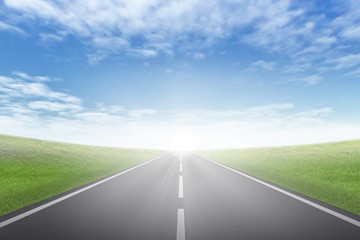 asphalt road through the green field and clouds on blue sky in summer day