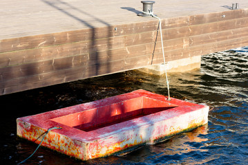 Small glass fiber working platform tied to a pier.