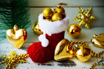 Christmas background in vintage style with Santa boot and bag, garland hanging on spruce branches on wooden planks in Shabby Chic style. New Year winter holidays concept. Empty place for photo or text