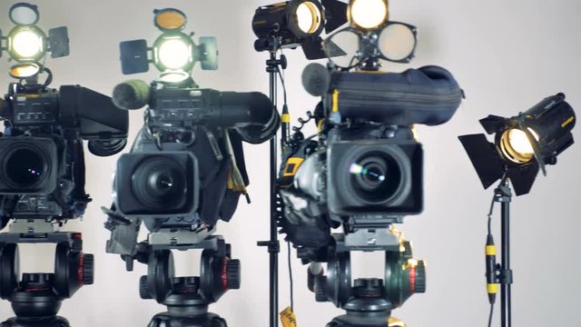 Several video cameras with working lights. 