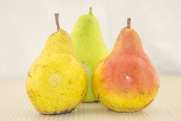 Fresh, juicy pear on a wooden base and white background color