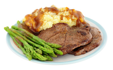 Fried venison steak meal with mashed potatoes and asparagus isolated on a white background