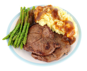 Fried venison steak meal with mashed potatoes and asparagus isolated on a white background