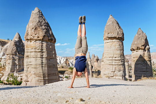 Young healthy tourist standing on hands woman travel at Cappadocia, Turkey. Yoga tour concept