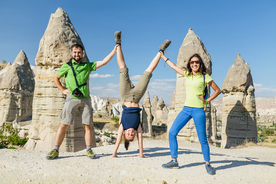 Group of happy caucasian Friends having fun while travelling among Cappadocia fairy chimneys at summer