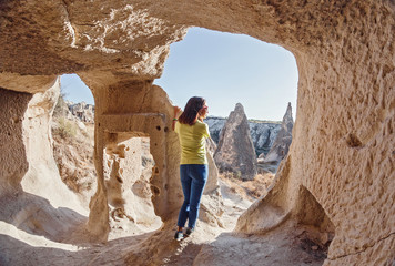 Traveler woman standing in cave underground city in Cappadocia, Turkey. Concept of archeology and...