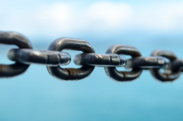 Closeup Old Steel Link Chains with Ocean background.