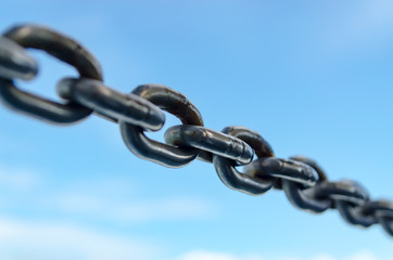 Closeup Old Steel Link Chains with Blue Sky background.