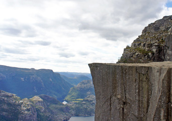 Edge of Preikestolen cliff (Prekestolen or Pulpit Rock) at fjord Lysefjord, famous and popular...