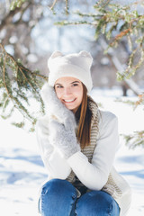 Girl in hat and mittens smiling in the winter