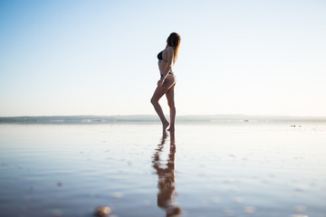 Fototapeta na wymiar Young girl in green bikini at the beach