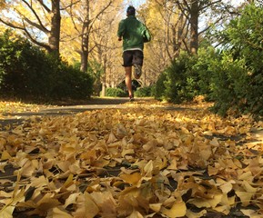 Man running on leafy autumn path