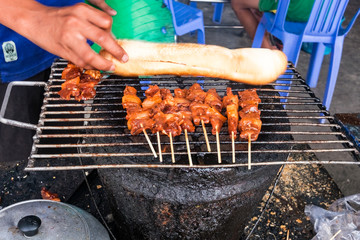 street food Cambodia. kebab on bamboo stick and French baguette