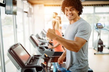 Fototapeta na wymiar Young handsome man doing cardio training in gym