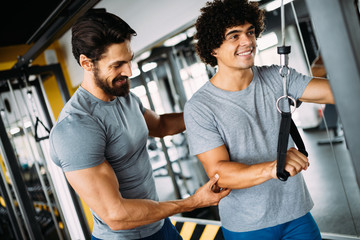 Young handsome man working with help from instructor