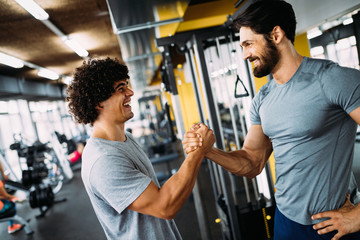 Two young men meeting at gym and giving each other handshake