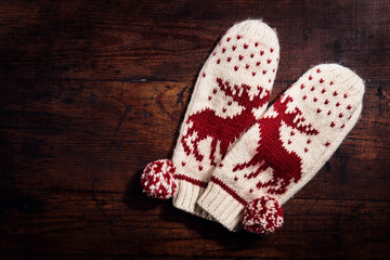 Knitted warm gloves on wood