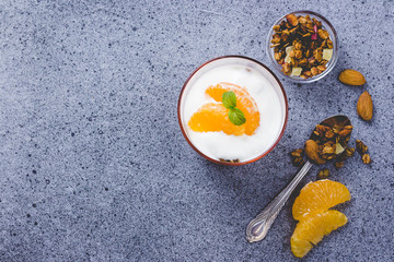 Tangerine yogurt granola dessert on concrete background. Top view, copy space.