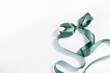 Folded green ribbon on white