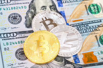 Coins of cryptocurrency lying over one hundred american dollar bills