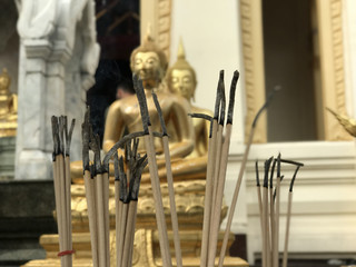 Incense in front of Golden buddha statue