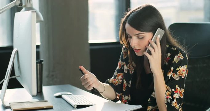 Attractive serious woman talk phone in office focused on work businesswoman call use computer corporate technology work portrait Slow Motion Shot on RED EPIC camera