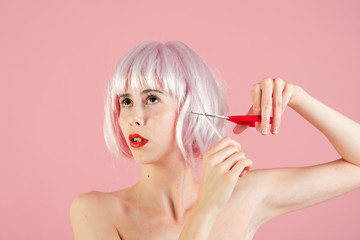 Woman in wig on pink background.