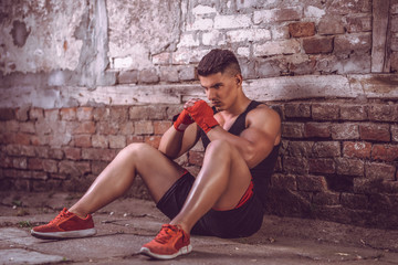 Portrait of muscular fit man who resting after box training.