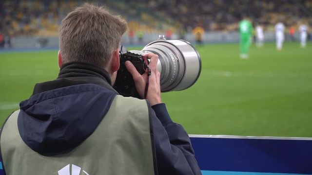 Photographers shoot on the pitch during a match