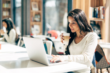 Beautiful brunette enjoying coffee and working