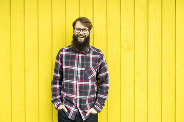 Fototapeta na wymiar hipster man in front of a wooden yellow wall