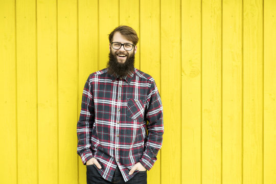 hipster man in front of a wooden yellow wall