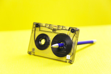 Audio cassette and a pencil. Music of the past. Audio cassette with music of 80 years and a pencil...