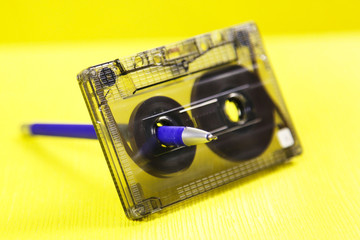Audio cassette and a pencil. Music of the past. Audio cassette with music of 80 years and a pencil...