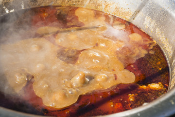 Pot goulash cooked over a fireplace on a tripod.