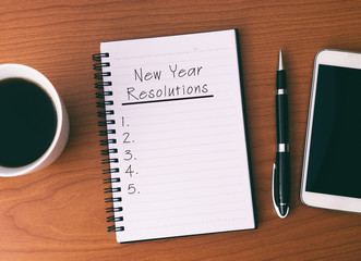 New Year's Resolution List on Notepad, background Coffee, Pen and Smart Phone.