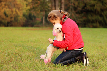 Obraz premium A girl in a red sweater lies on a green grass in an autumn park