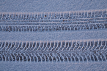 Traces from car tires on snow from two different types of tires
