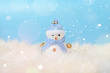 Happy snowman standing in blue winter christmas snow background. Merry christmas and happy new year greeting card with copy-space. Christmas celebration holiday background.
