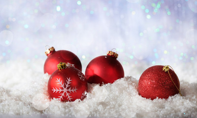 Fototapeta na wymiar Red Christmas balls on Christmas snowy bokeh background