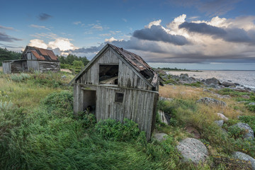 Obraz premium Abandoned houses in the Baltic Sea. Shore, nature and ruins facilities architecture concept. Mohni, small island in Estonia, Europe.