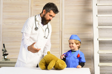 Father and kid with happy faces playing doctor.