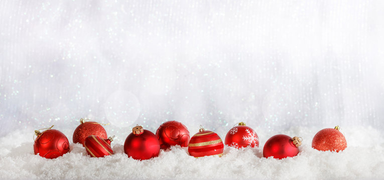 Red Christmas balls row on Christmas snowy bokeh background