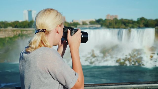 A woman tourist takes pictures of the famous Niagara Falls. From the Canadian side a good view of the waterfall