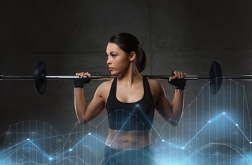 young woman flexing muscles with barbell in gym